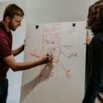 man drawing on dry-erase board